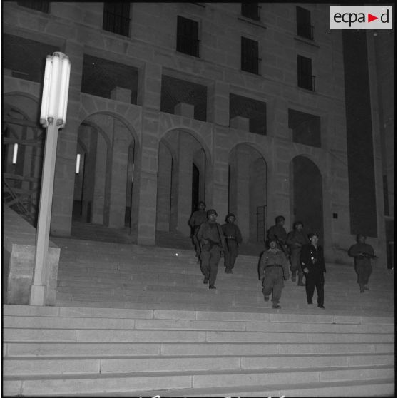 Patrouille de nuit des appelés et rappelés de la section Algérie du Service cinématographique des Armées (SCA) dans les rues d'Alger.