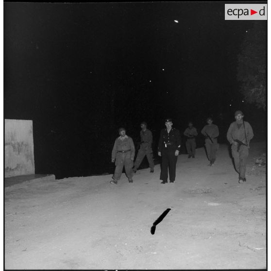 Patrouille de nuit des appelés et rappelés de la section Algérie du Service cinématographique des Armées (SCA) dans les rues d'Alger.