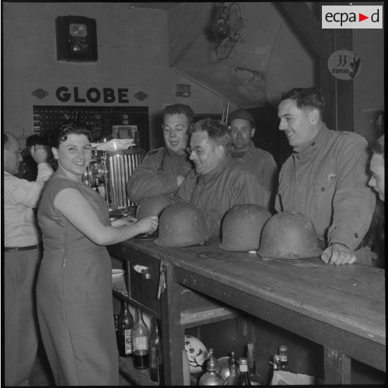 Moment de détente dans un café bar pour des rappelés du Service cinématographique des Armées (SCA) après une patrouille de nuit à Alger.