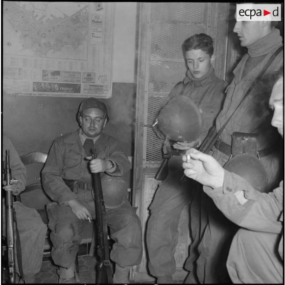 Attente de rappelés du Service cinématographique des Armées avant le départ en patrouille de nuit à Alger.