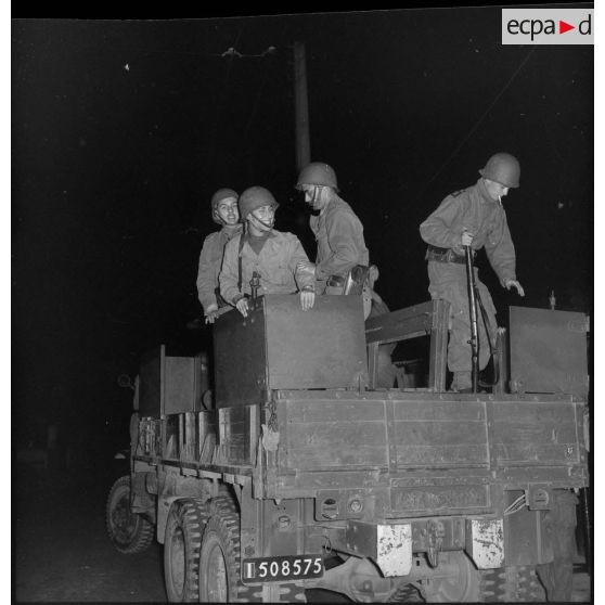 Des rappelés du Service cinématographique des Armées (SCA) à bord d'un véhicule GMC 6x6 à Alger.
