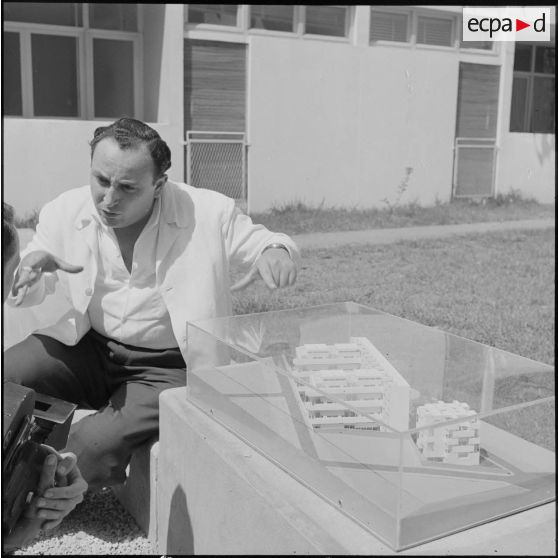 Monsieur Guigui présentant la maquette d'un futur immeuble.