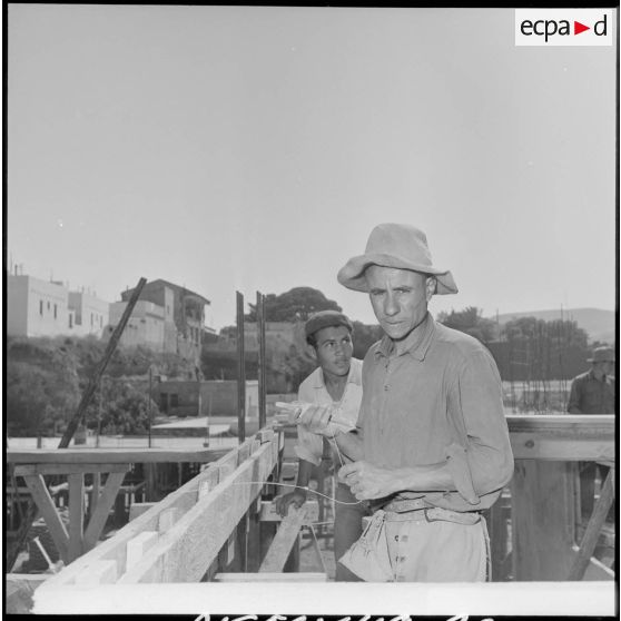 Des ouvriers algériens travaillent sur les chantiers de construction de nouveaux immeubles pour la ville d'Oran.