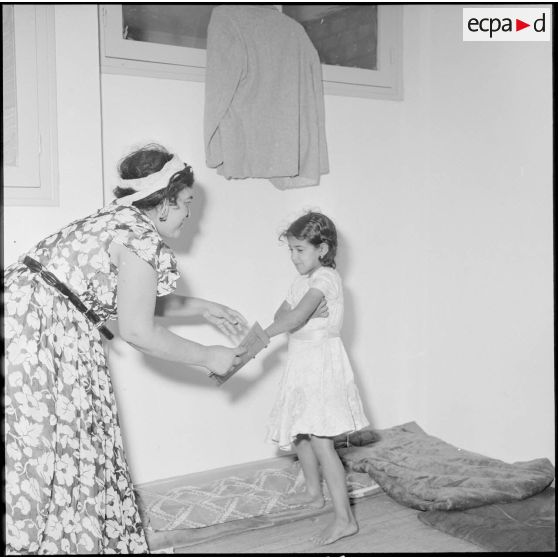 Une petite fille et sa mère dans leur logement familial.