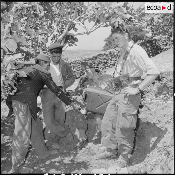 Des soldats du 2e régiment d'infanterie (RI) offrant de l'eau aux ouvriers algériens.