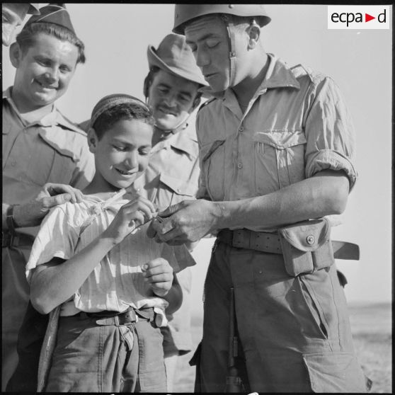Des soldats de la 20e DI et un jeune Algérien.
