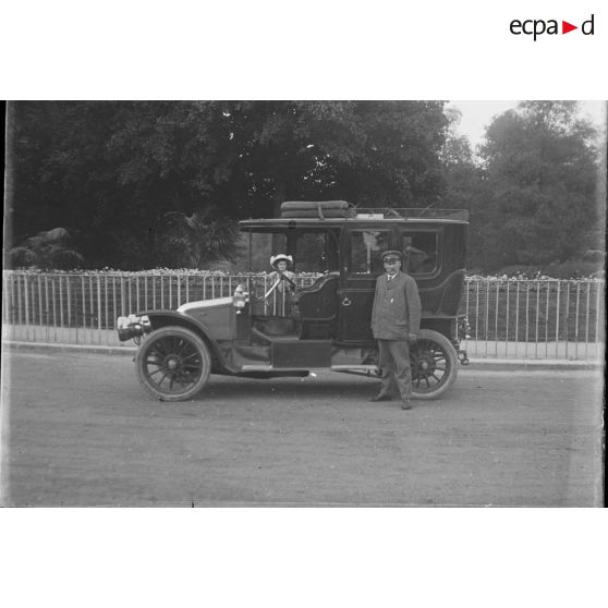 [Chauffeur posant près d'une voiture.]
