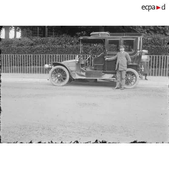 [Chauffeur posant près d'une voiture.]