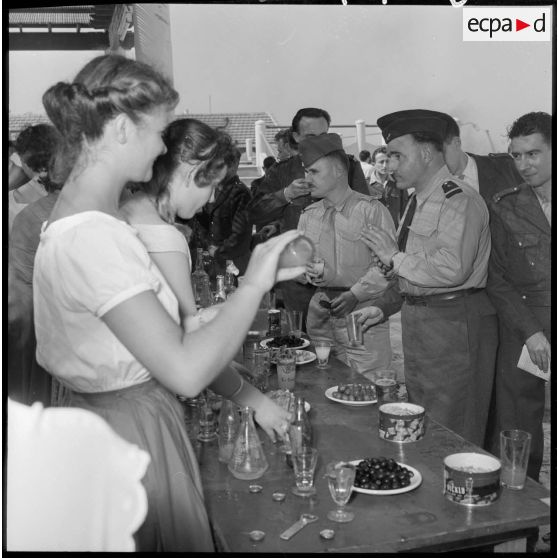 Des officiers de réserve et des jeunes femmes se restaurent au buffet organisé lors d'une réception à Maison-Blanche.