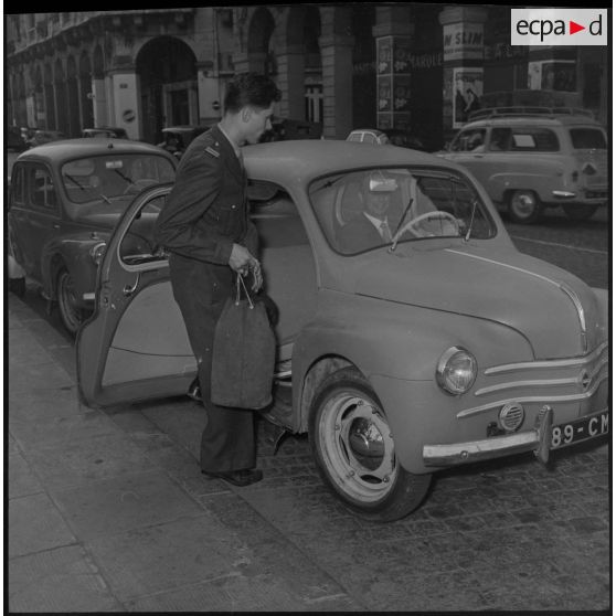 Un lieutenant embarquant à bord d'une voiture Citroën 4CV.