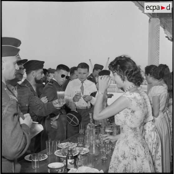 Des officiers de réserve et des jeunes femmes se restaurent au buffet organisé lors d'une réception à Maison-Blanche.