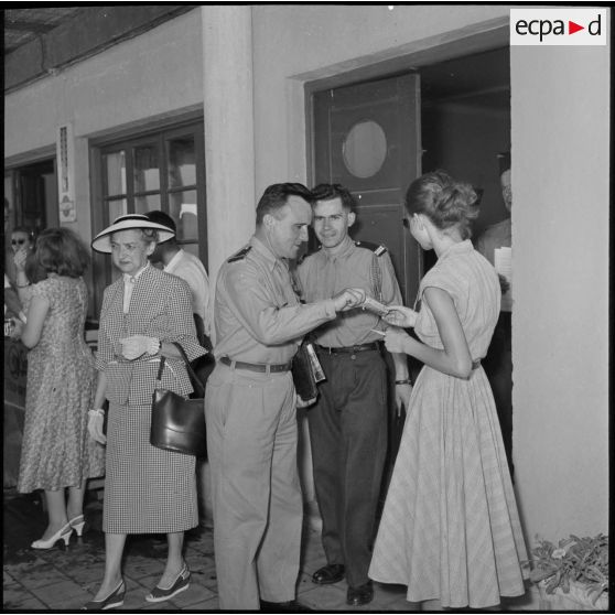 Des jeunes femmes proposent des cigarettes aux officiers de réserve invités à la réception organisée à Maison-Blanche.