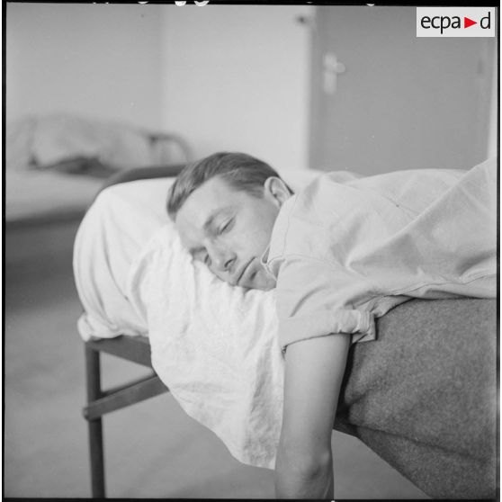 Un soldat dormant sur un lit.