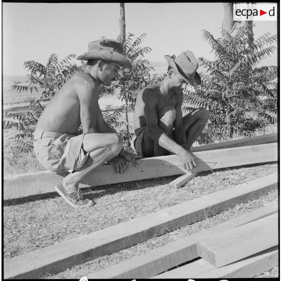 Des soldats d'un bataillon du génie mesurant une pièce de bois.