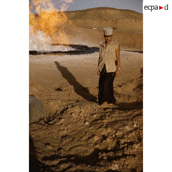 [Algérie, 1958-1961. Méhariste posant devant des flammes provenant d'un puits de pétrole.]