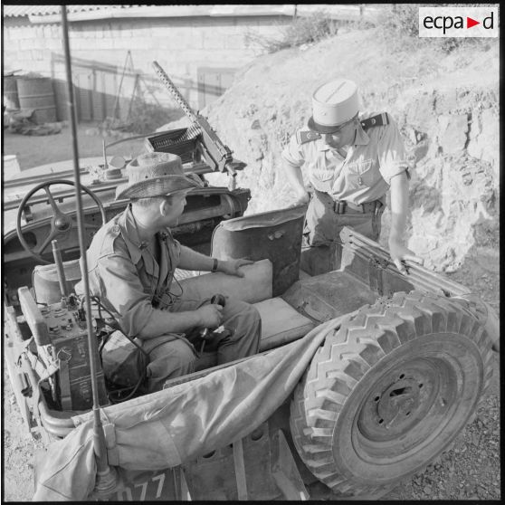 Le lieutenant SAS Burthey montrant l'impact d'une balle dans le siège de la jeep.