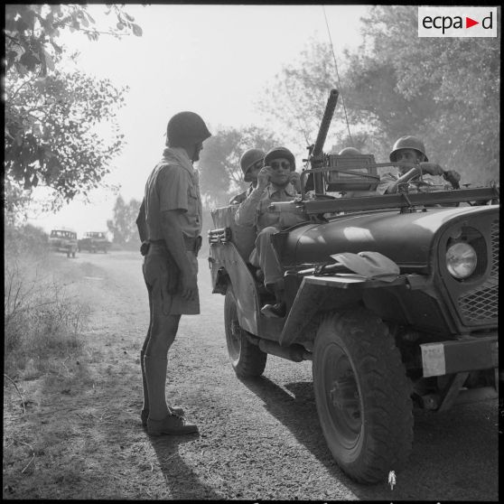 Des soldats à bord d'une jeep Delahaye sur les lieux de la fusillade.