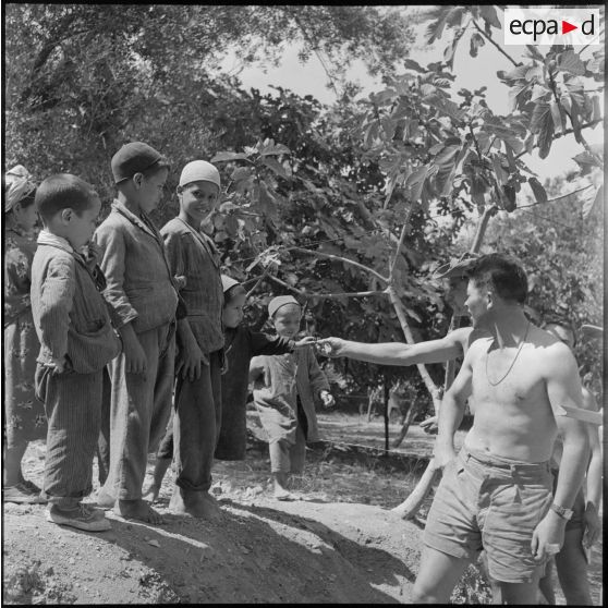 Les cuisiniers d'un régiment de l'infanterie basé à Ténès donnant de la viande aux enfants.