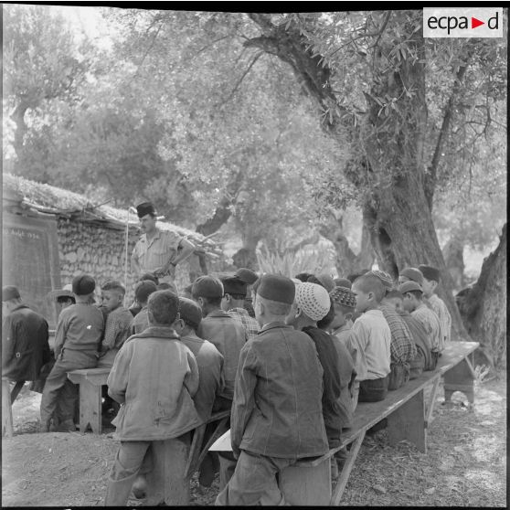 Un soldat de l'infanterie faisant la classe en plein-air aux enfants de Loudalouz.