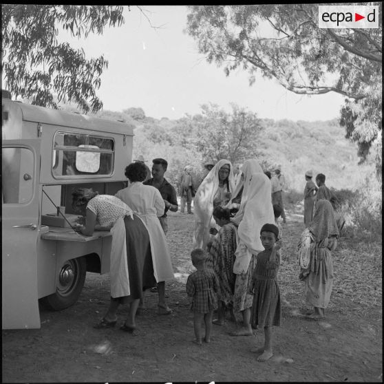 Des femmes et des enfants attendant de recevoir des soins au camion ambulance.