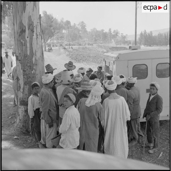 Une foule d'habitants attendant des soins auprès du camion ambulance de la Croix-Rouge.