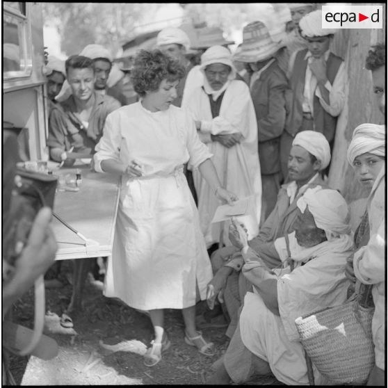 Des habitants de la région de Ténès attendant d'être soignés par une infirmière de la Croix-Rouge.