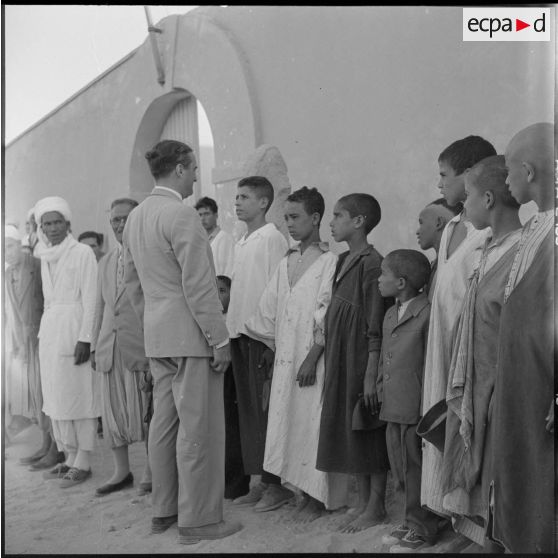 Le ministre parle avec l'instituteur et les élèves du village de Négrine.