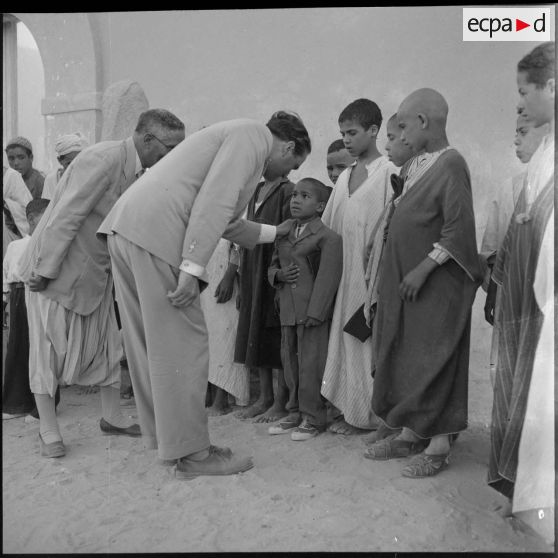 Le ministre parle avec l'instituteur et les élèves du village de Négrine.