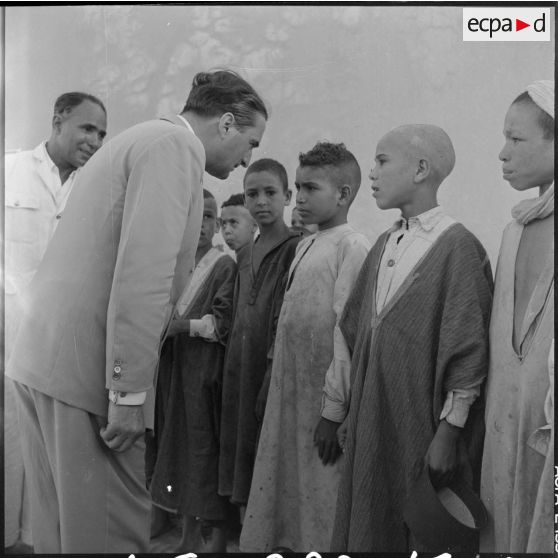 Le ministre parle avec l'instituteur et les élèves du village de Négrine.