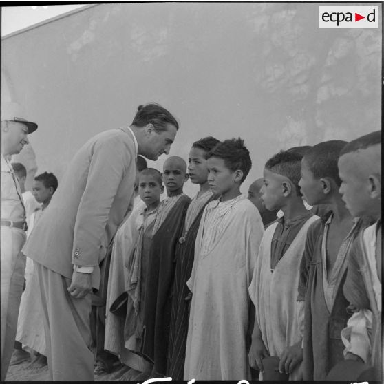 Le ministre parle avec l'instituteur et les élèves du village de Négrine.