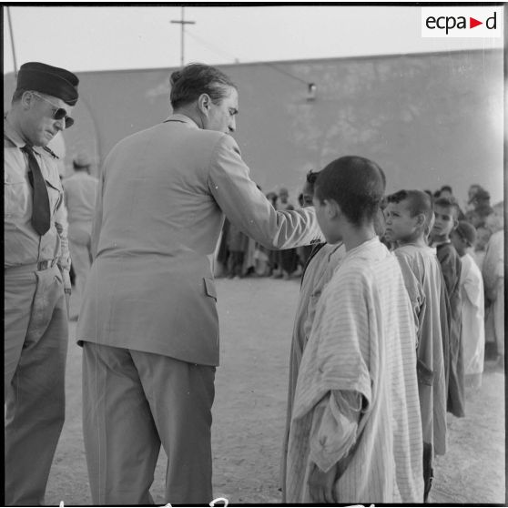 Le ministre parle avec l'instituteur et les élèves du village de Négrine.