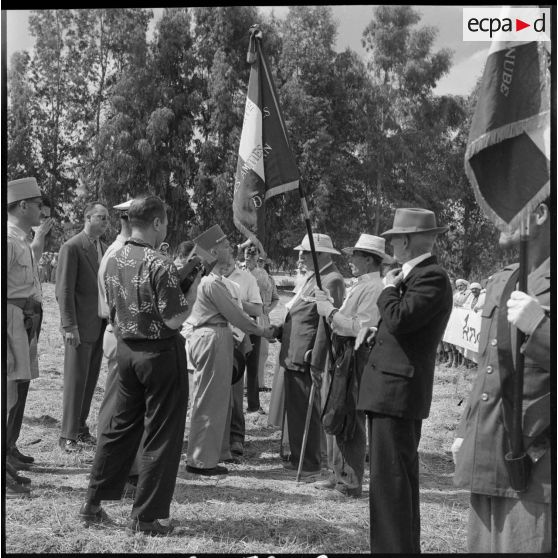 Le général Olié salue les drapeaux des anciens combattants algériens de la CM de Dra-el-Mizan.