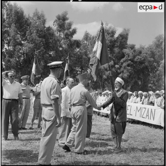 Le général Olié salue les drapeaux des anciens combattants algériens de la CM de Dra-el-Mizan.