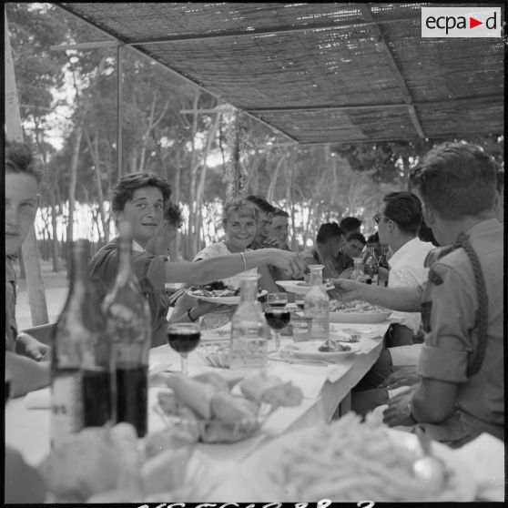 Au cours du repas fraternel au restaurant La gondole. Une jeune étudiante d'Alger sert de la viande à un soldat.