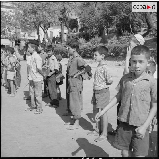 Les petits cireurs, vivement intéressés par le défilé des troupes.