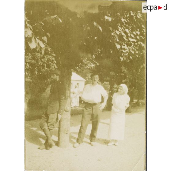 [Infirmière et deux malades posant sous un arbre, s.d.]