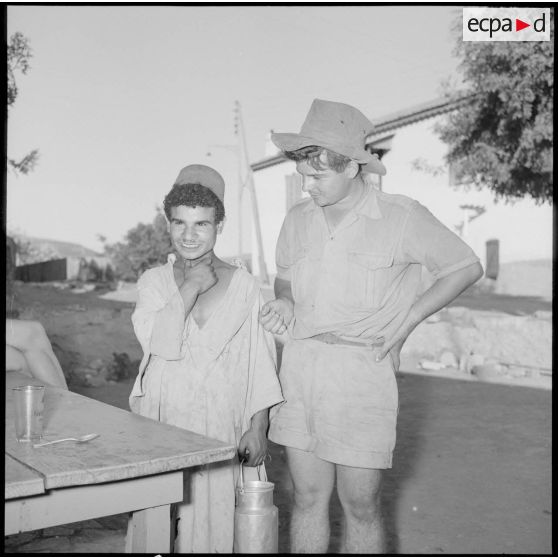 Le soldat Serge Godefroy discute avec un jeune Algérien du village.