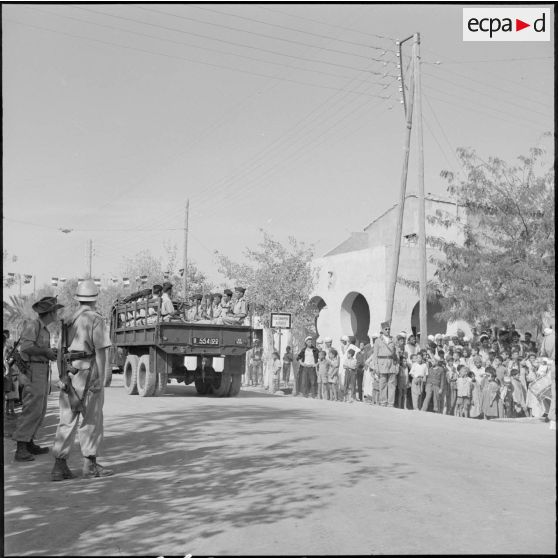 Des soldats du 47e BI défilent à bord d'un GMX 6x6.