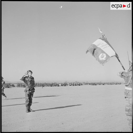 Le général Massu salue l'emblème du 1er REP (régiment étranger parachutiste).