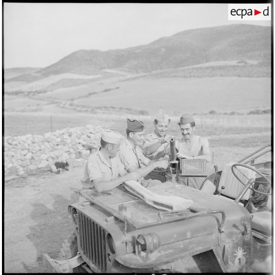 Les soldats Couillon, Lebaupin, Guibert et Grelier devant une mitrailleuse de 12,7 mm installée sur une jeep.