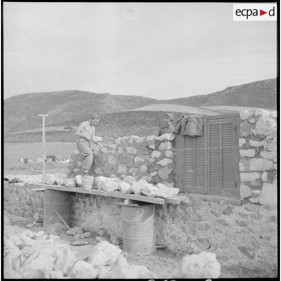Les soldats Bourdequin et Diandrieu travaillent à la construction d'un mur.