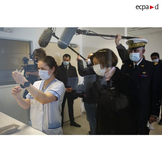 Madame Florence Parly assiste à la préparation d'une dose de vaccin par une infirmière en compagnie du médecin général inspecteur Vincent Duverger au sein de l'hôpital d'instruction des armées (HIA) Bégin à Saint-Mandé.