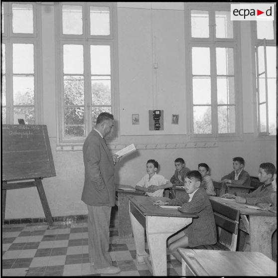 L'instituteur lit la leçon.