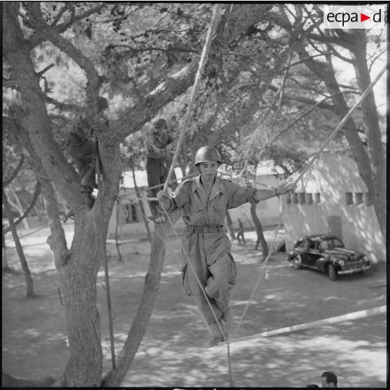 Au camp du Lido à Hussein Dey, un appelé effectue un parcours d'entraînement dans les arbres.