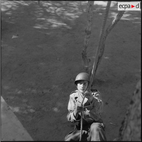 Au camp du Lido à Hussein Dey, un appelé grimpe à la corde.