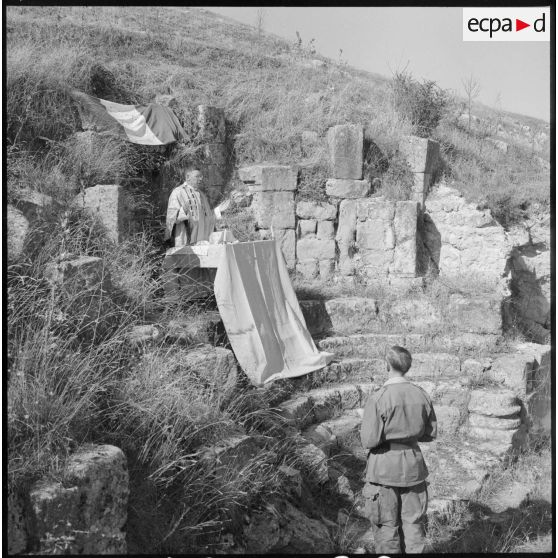Vue rapprochée sur l'aumônier Zanolini qui célèbre la messe dans les ruines de la basilique de Thibilis.