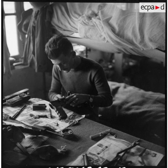 Le soldat Arnould nettoie son fusil-mitrailleur.