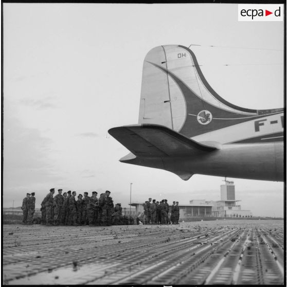 Sur un terrain d'aviation, les soldats du 2e régiment de parachutistes coloniaux (RPC) patientent avant d'embarquer.