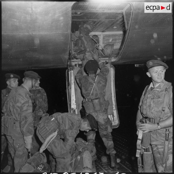 Les soldats du 2e régiment de parachutistes coloniaux (RPC) chargent leurs paquetages dans la soute de l'avion.