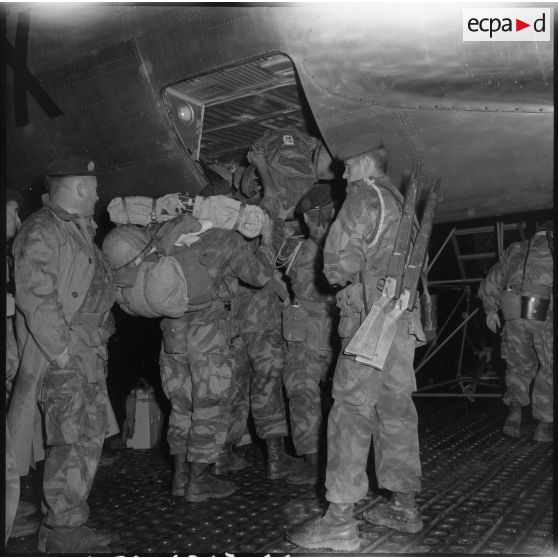 Les soldats du 2e régiment de parachutistes coloniaux (RPC) chargent leurs paquetages dans la soute de l'avion.